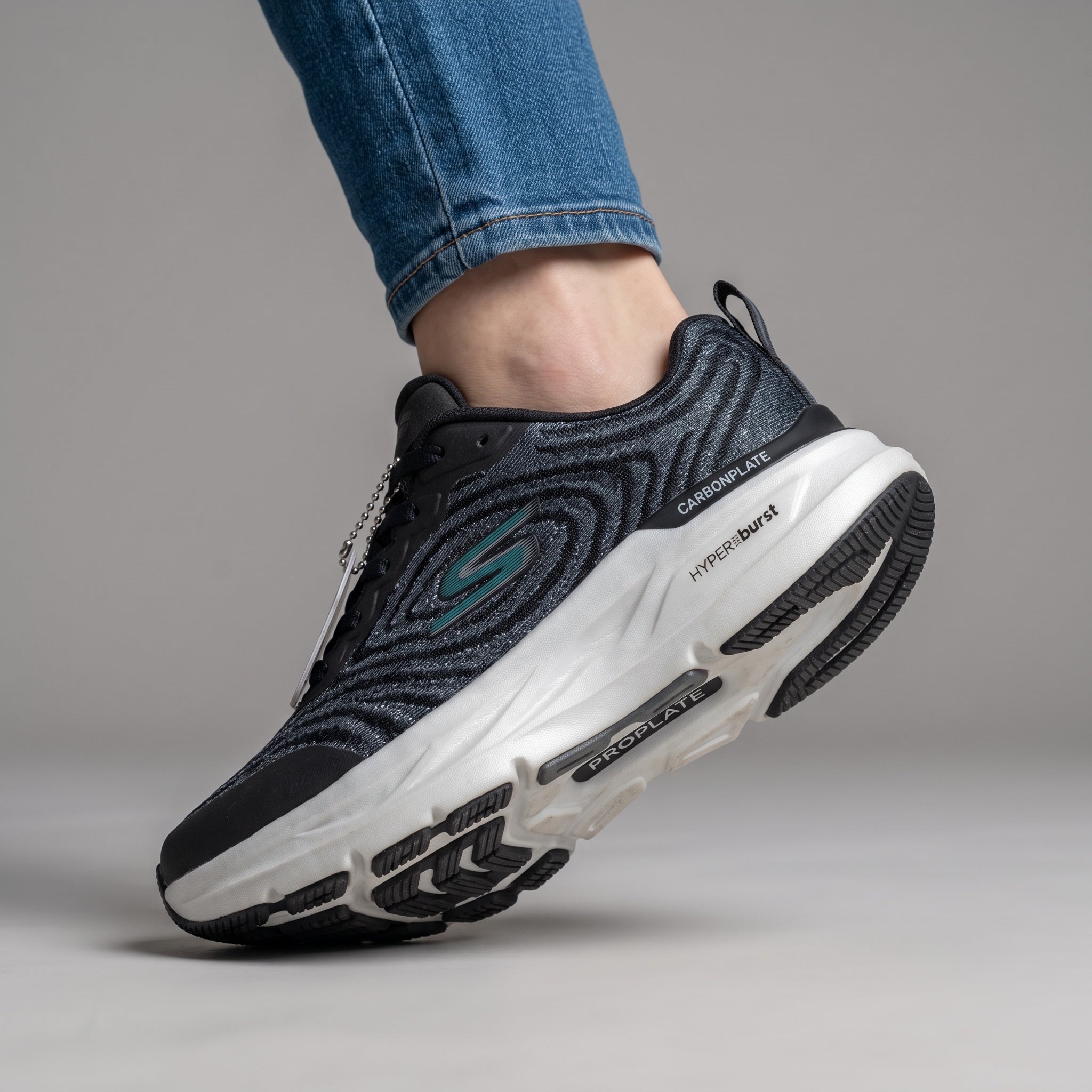 black Skechers knit running sneakers with white chunky midsole showing Carbon Infused and Hyperburst text