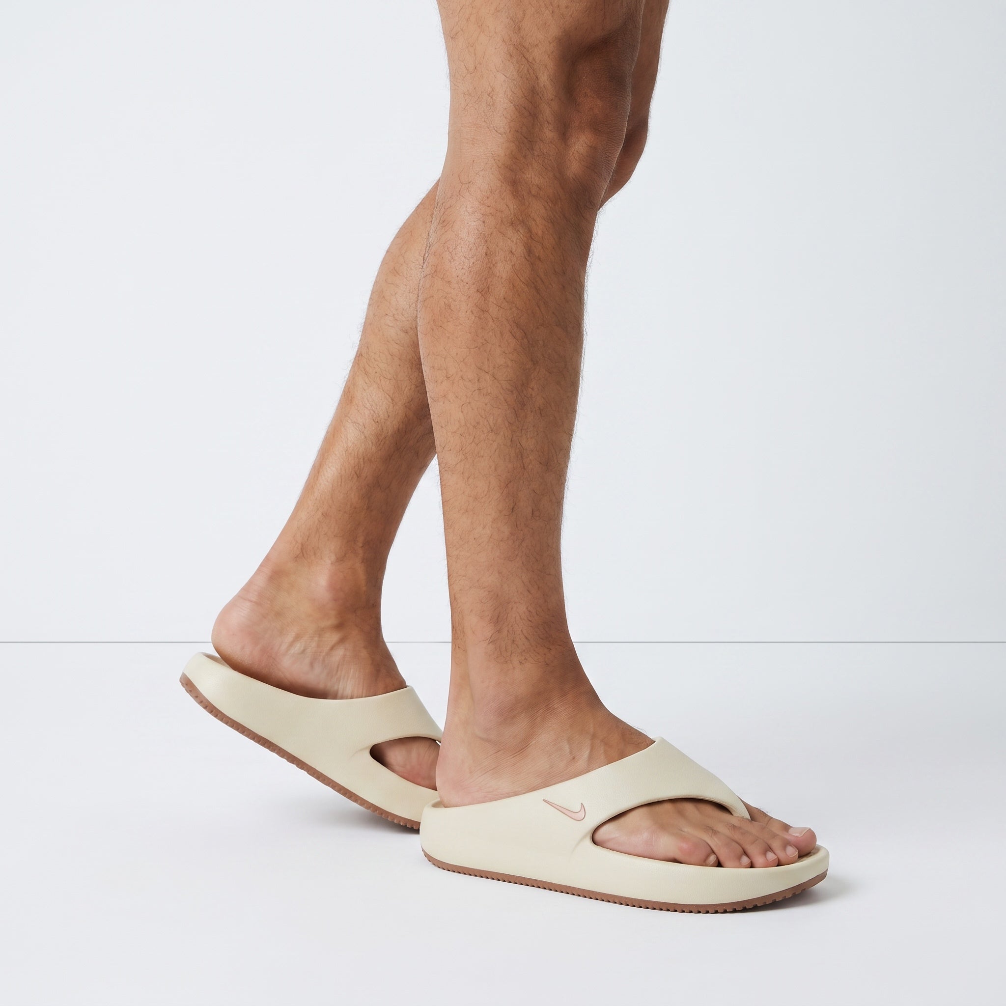 beige Nike foam slide with brown sole and metallic Swoosh