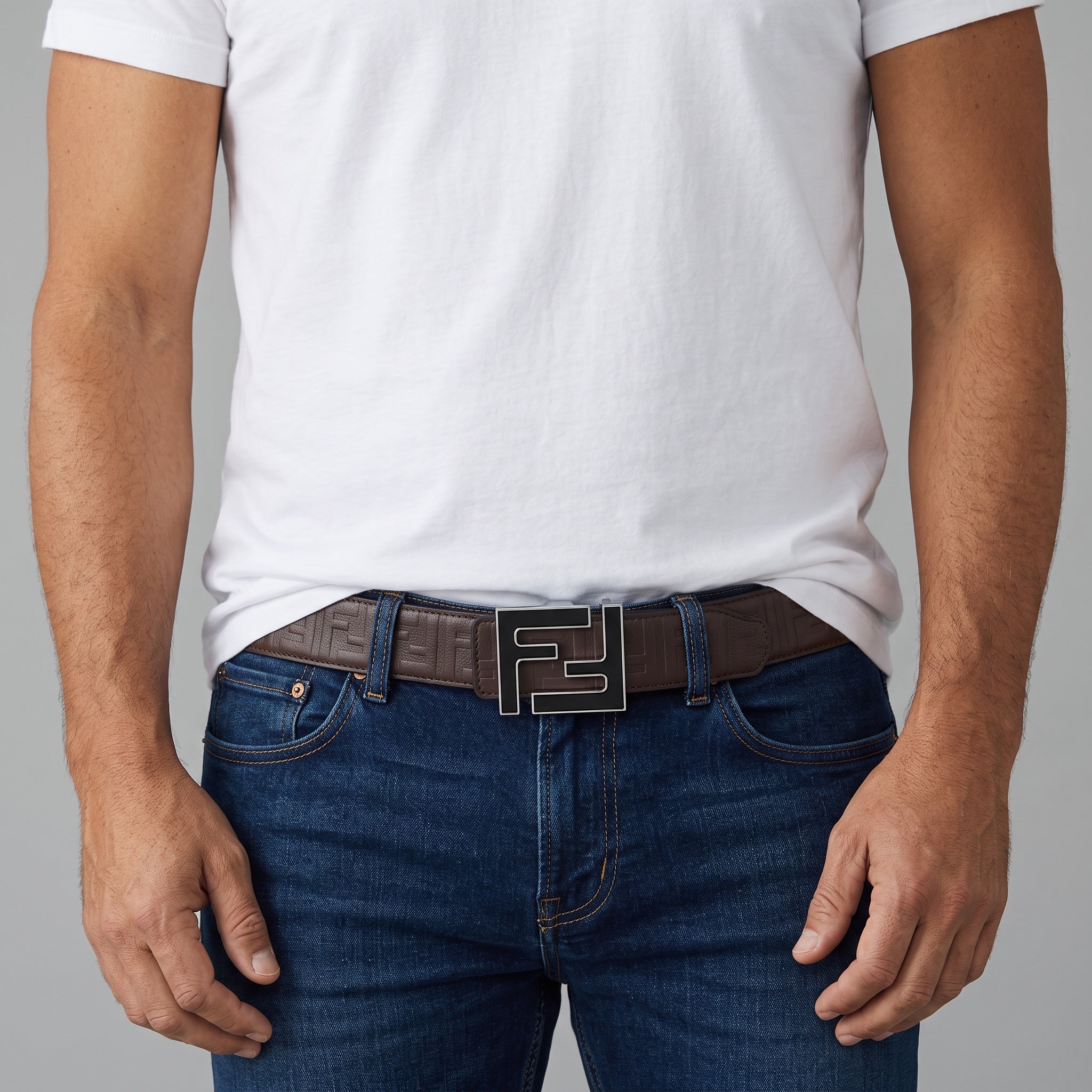 Brown belt with repeating FF motif and large double-F metal buckle worn with jeans