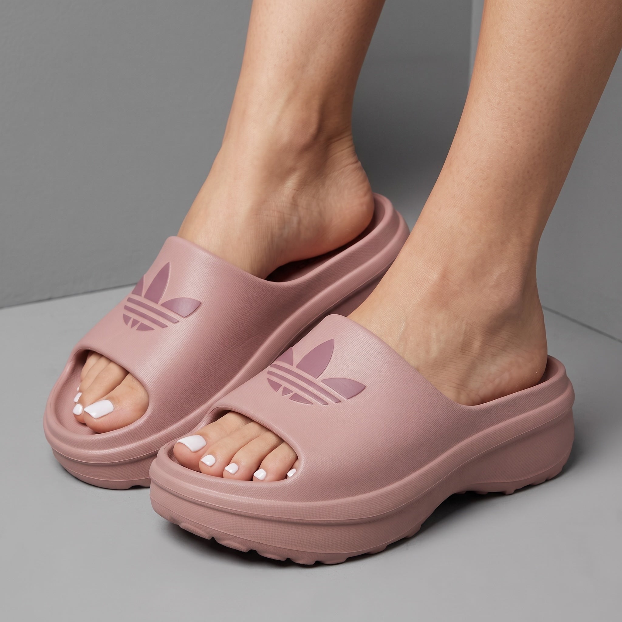 blush pink Adidas platform slide with embossed trefoil logo