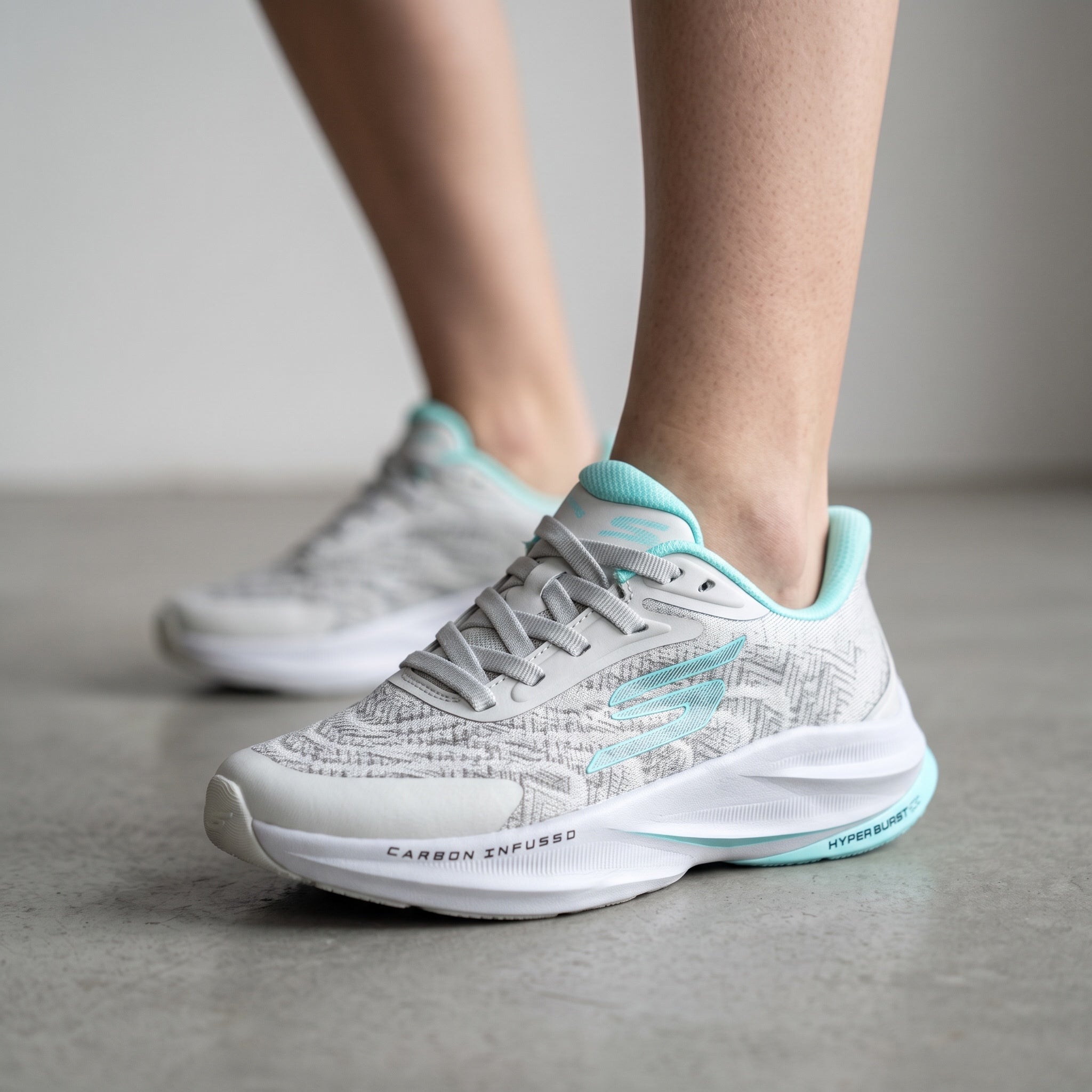 Light grey Skechers sneakers with aqua trim visible carbon infused and hyper burst markings