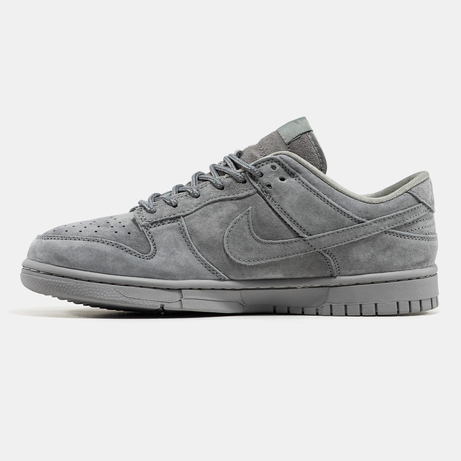 Grey Nike Dunk Low suede sneaker with small red Supreme box logo at heel