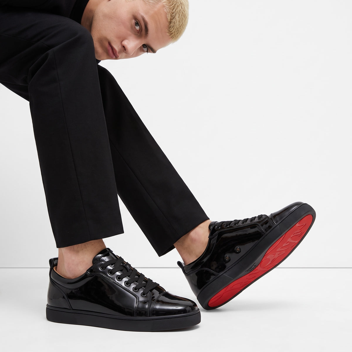 black patent low-top sneakers with red sole