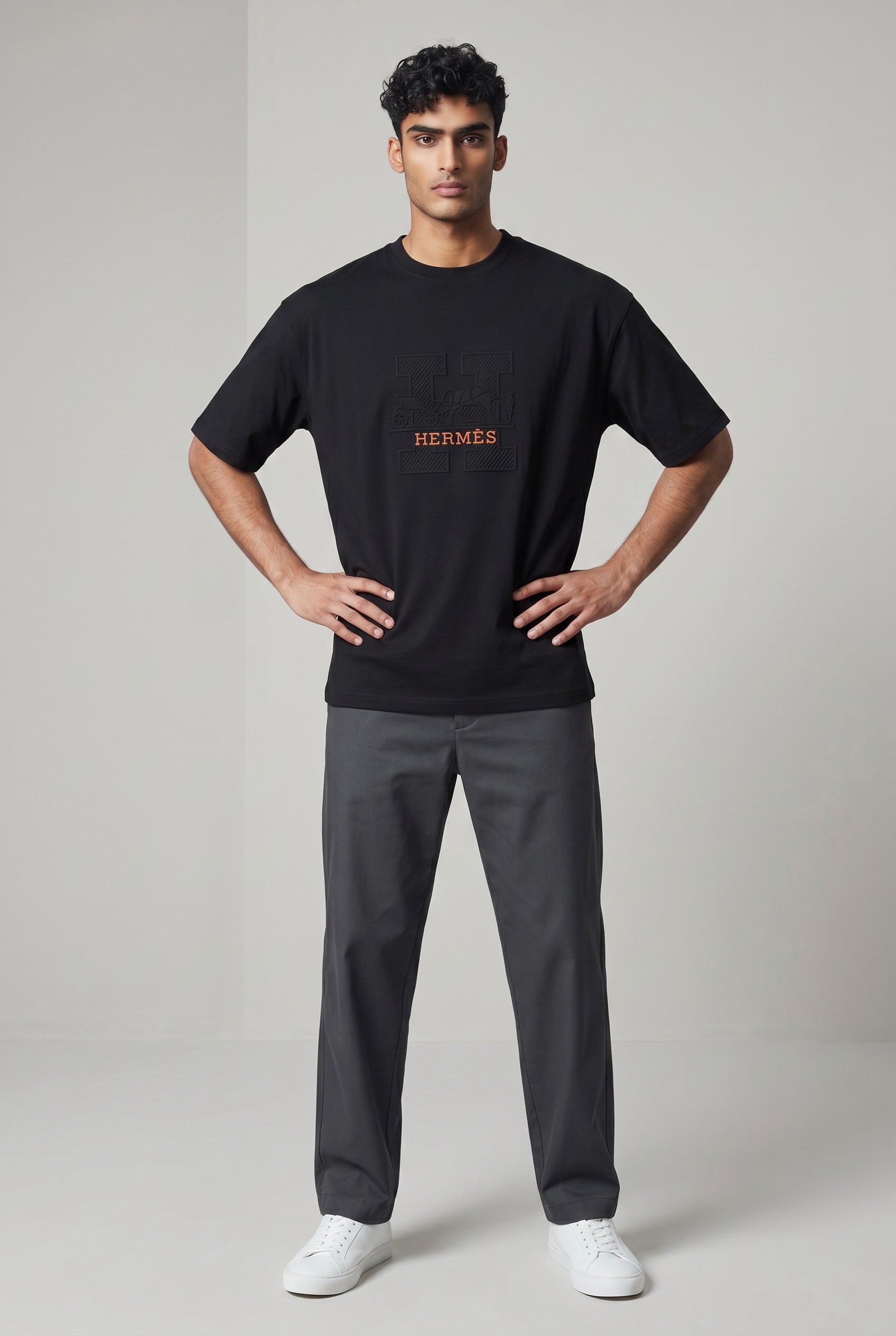 MASTERPIECE black cotton t-shirt with embossed Hermès H logo and orange tag detail. Crew neck, premium fit.