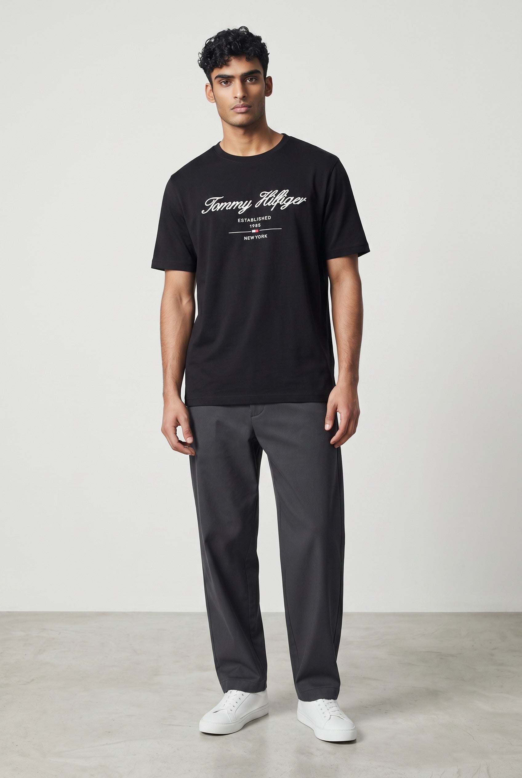 MASTERPIECE black cotton t-shirt with white Tommy Hilfiger script logo and established 1985 New York detail. Crew neck, short sleeves.