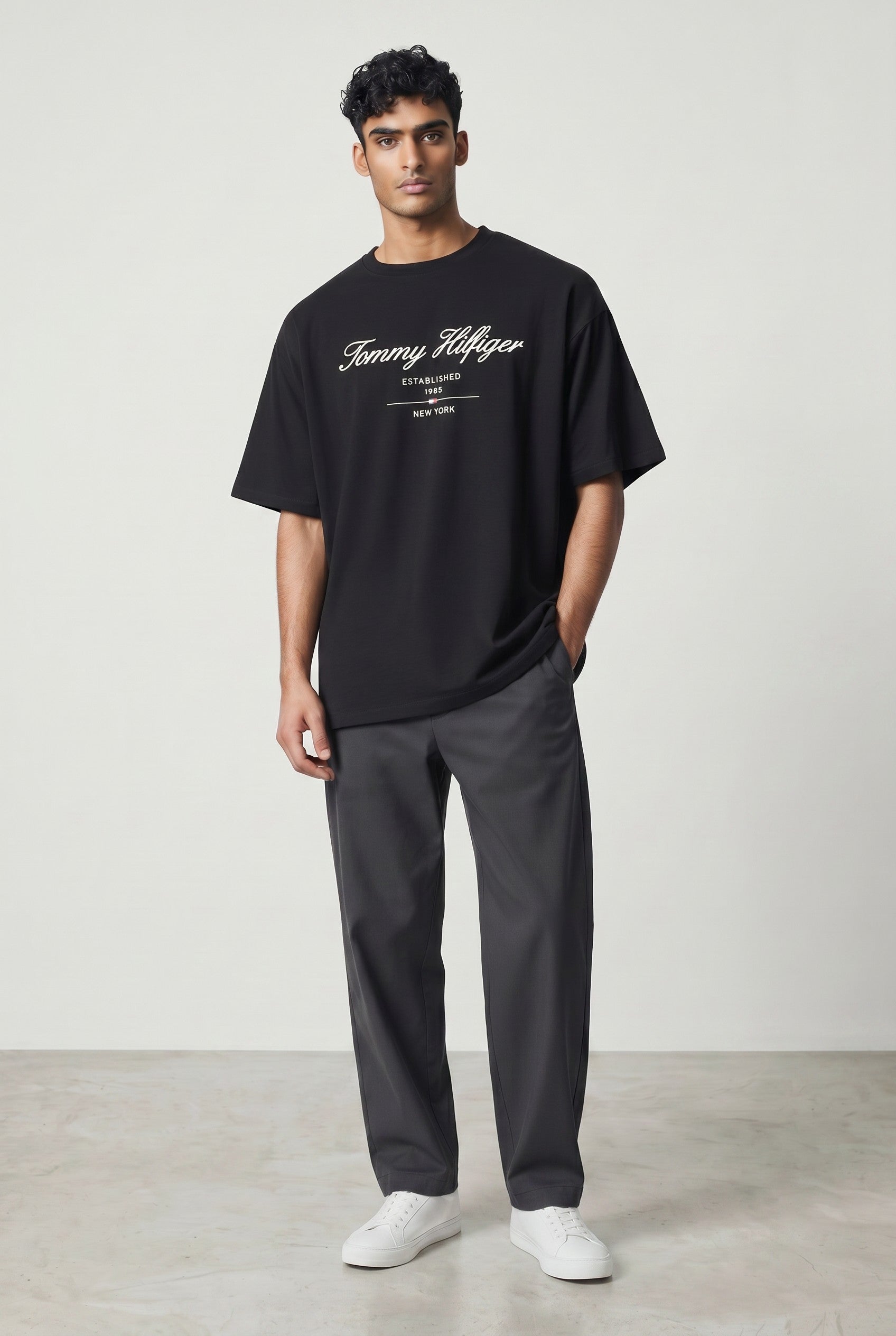 MASTERPIECE black cotton t-shirt with white Tommy Hilfiger script logo and crew neck. Model wears size M.