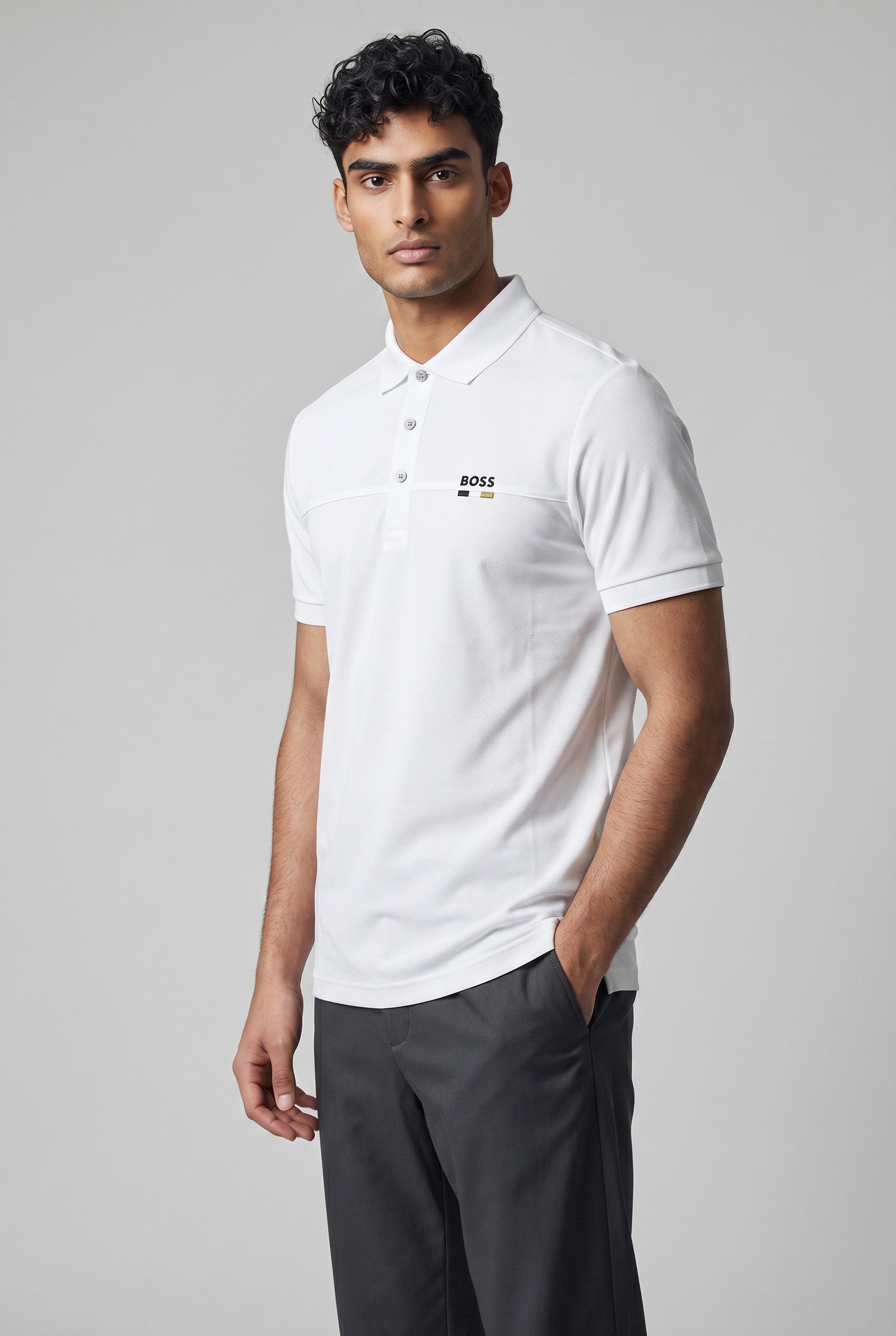 MASTERPIECE BOSS white polo shirt with subtle perforated logo detail and minimal chest logo accent. Textured breathable fabric, classic collar, button placket, tailored fit.