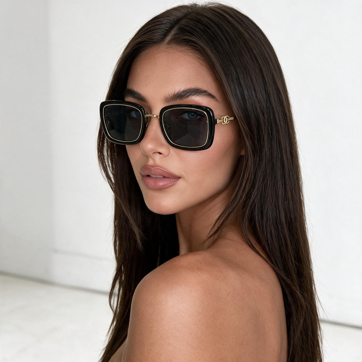 Black square Chanel sunglasses with gold trim on model