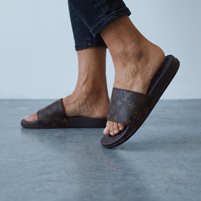 brown Louis Vuitton monogram slide sandals on model feet