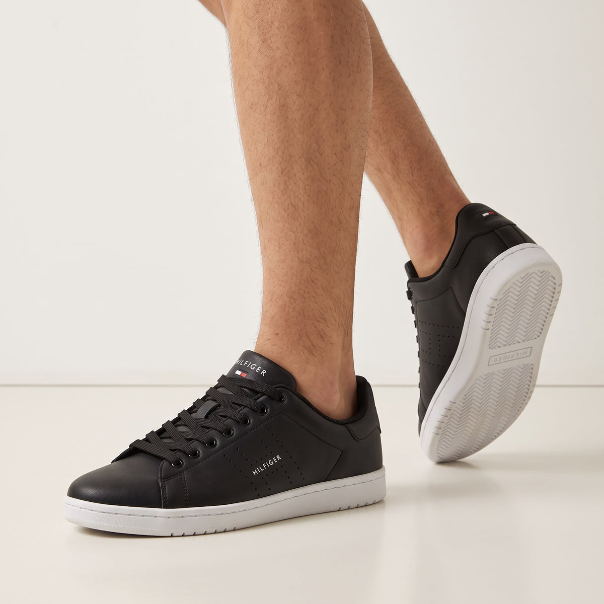 Tommy Hilfiger black low-top sneakers with white sole and perforated side