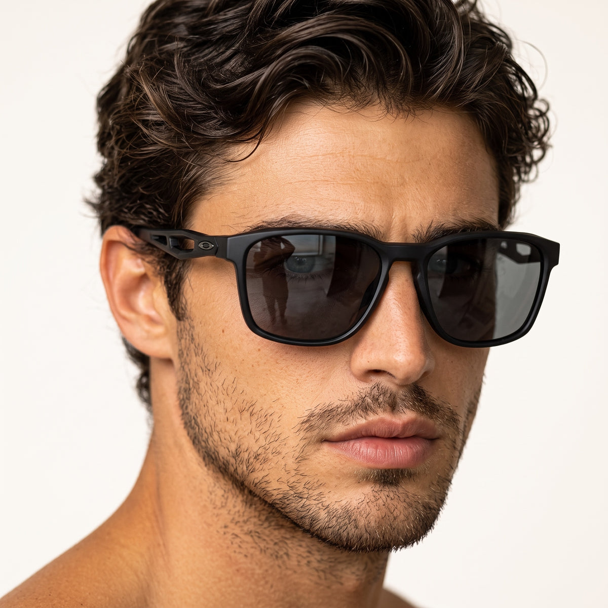 Close-up of a man wearing matte black Oakley sunglasses with dark smoke lenses