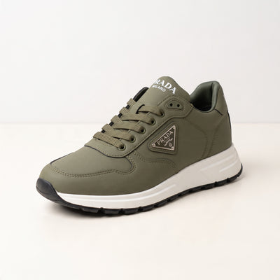 Olive green Prada low-top trainer with white chunky sole and triangular logo plaque