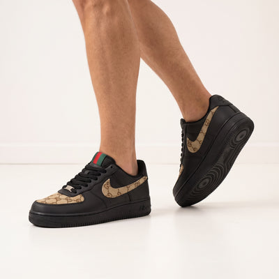 Black low-top sneakers with brown monogram Swoosh and green-red heel tab
