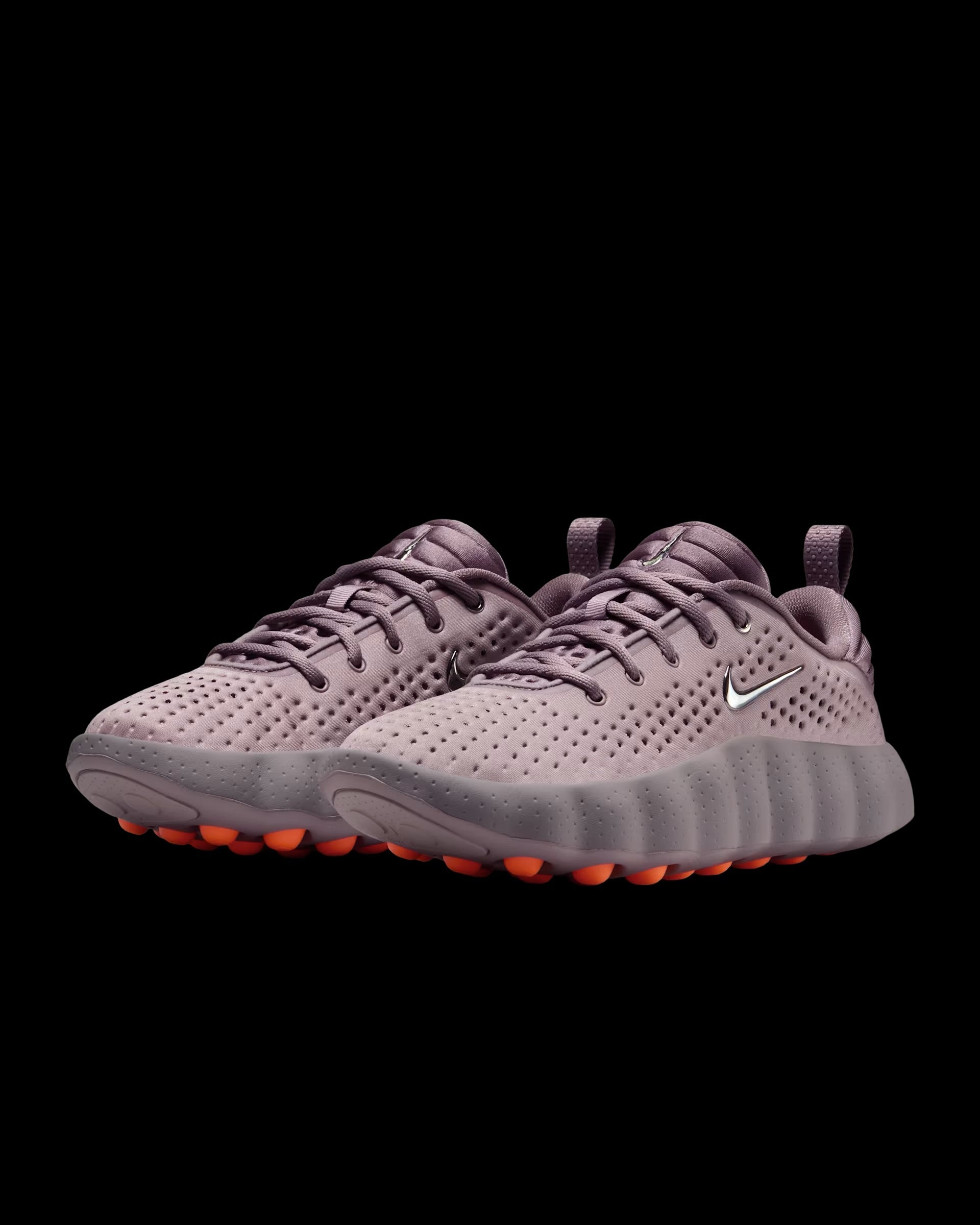 dusty pink nike sneaker with perforated upper and orange pod outsole