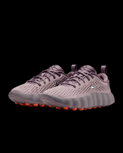 dusty pink nike sneaker with perforated upper and orange pod outsole