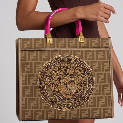 Brown Fendi FF monogram tote with pink handles and gold hardware, embellished medallion on front