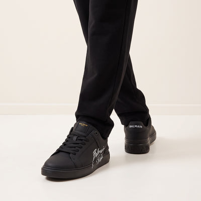 Black Balmain low-top sneakers with script logo on side and branded heel