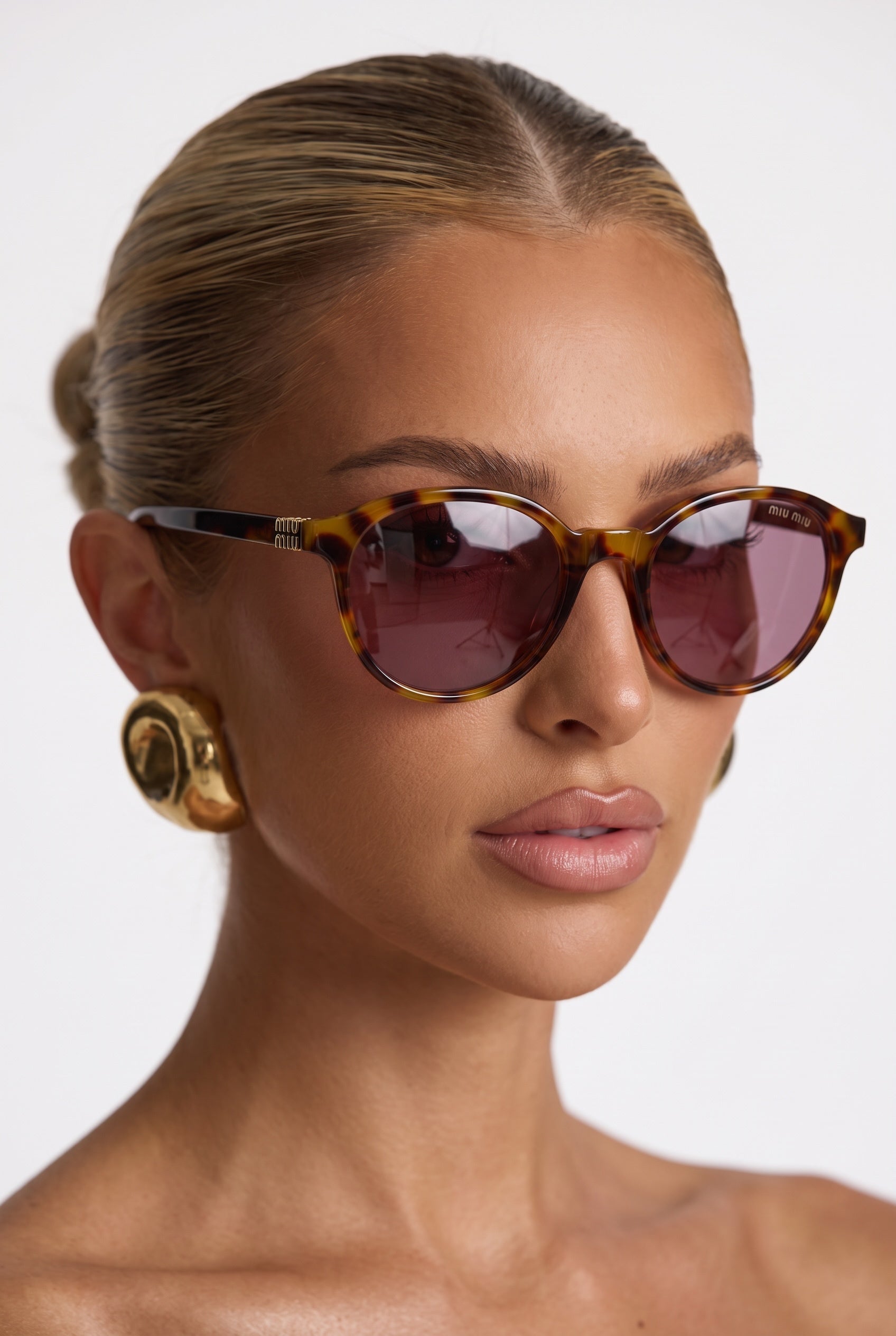 Miu Miu tortoiseshell round sunglasses with brown plum lenses on model