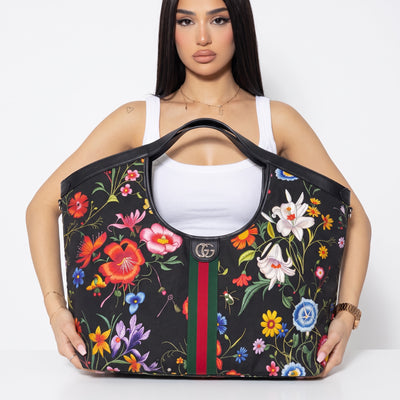 Black Gucci tote with colorful floral print, GG logo and green-red-green stripe