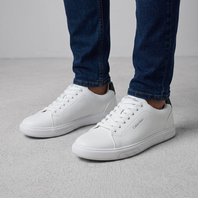 White low-top Calvin Klein sneakers with black heel tab and branded sole