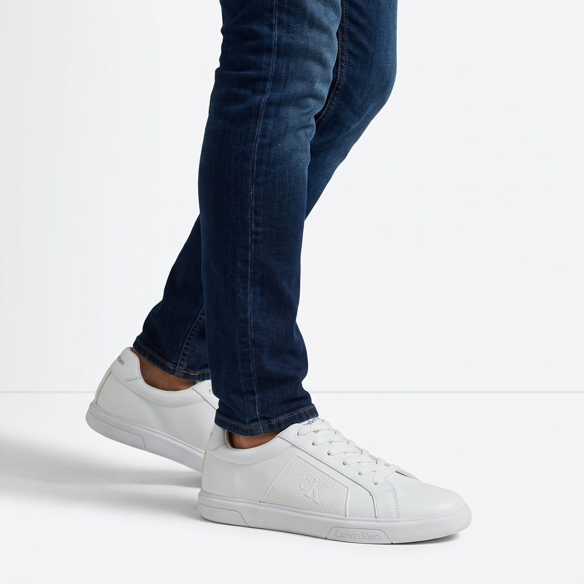 White Calvin Klein low-top sneakers with embossed CK logo