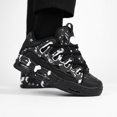 black chunky low-top sneaker with white splatter print and sculpted sole