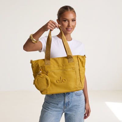 Mustard Alo tote bag with logo webbing straps and attached round pouch