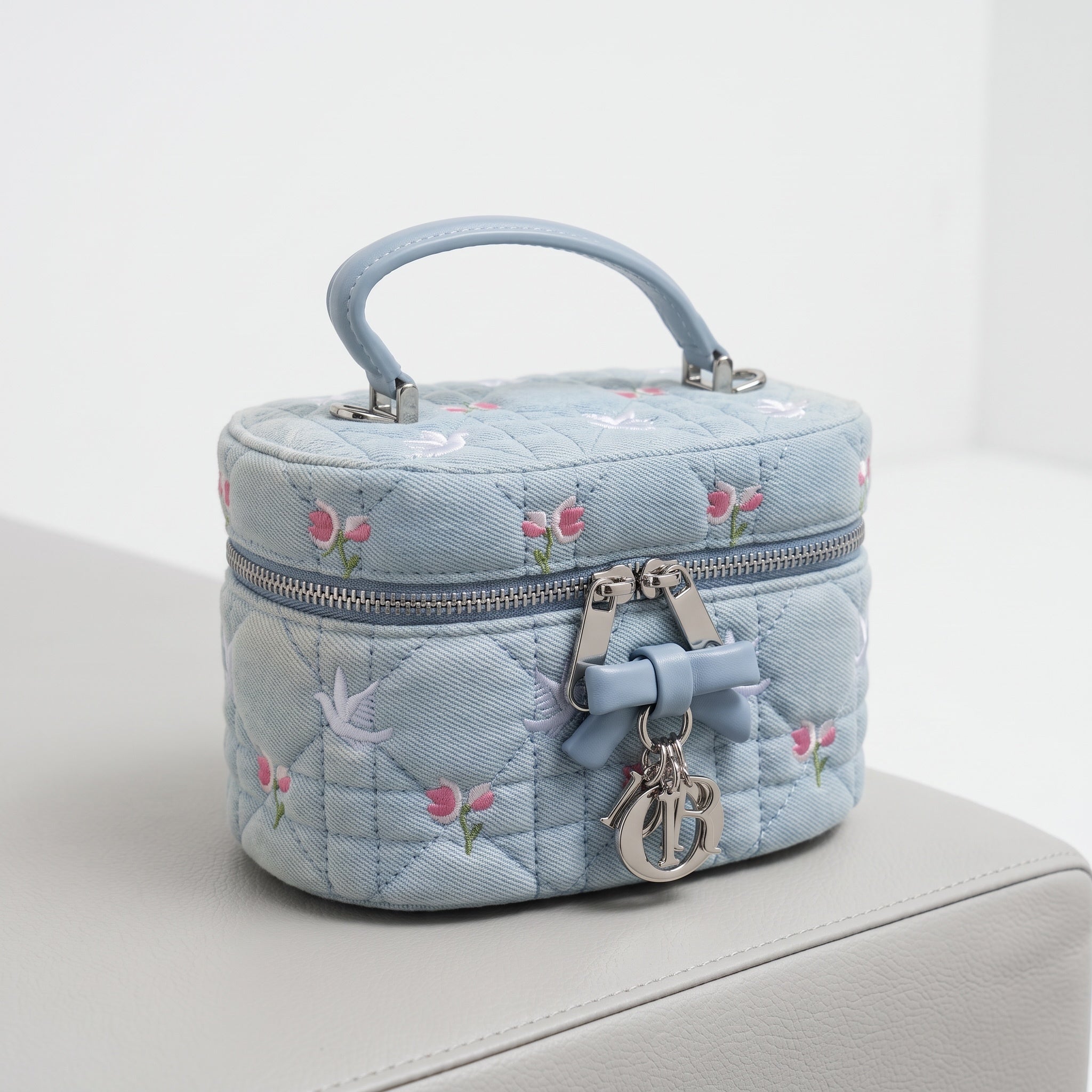 baby blue Dior quilted vanity pouch with embroidered flowers and silver Dior charms