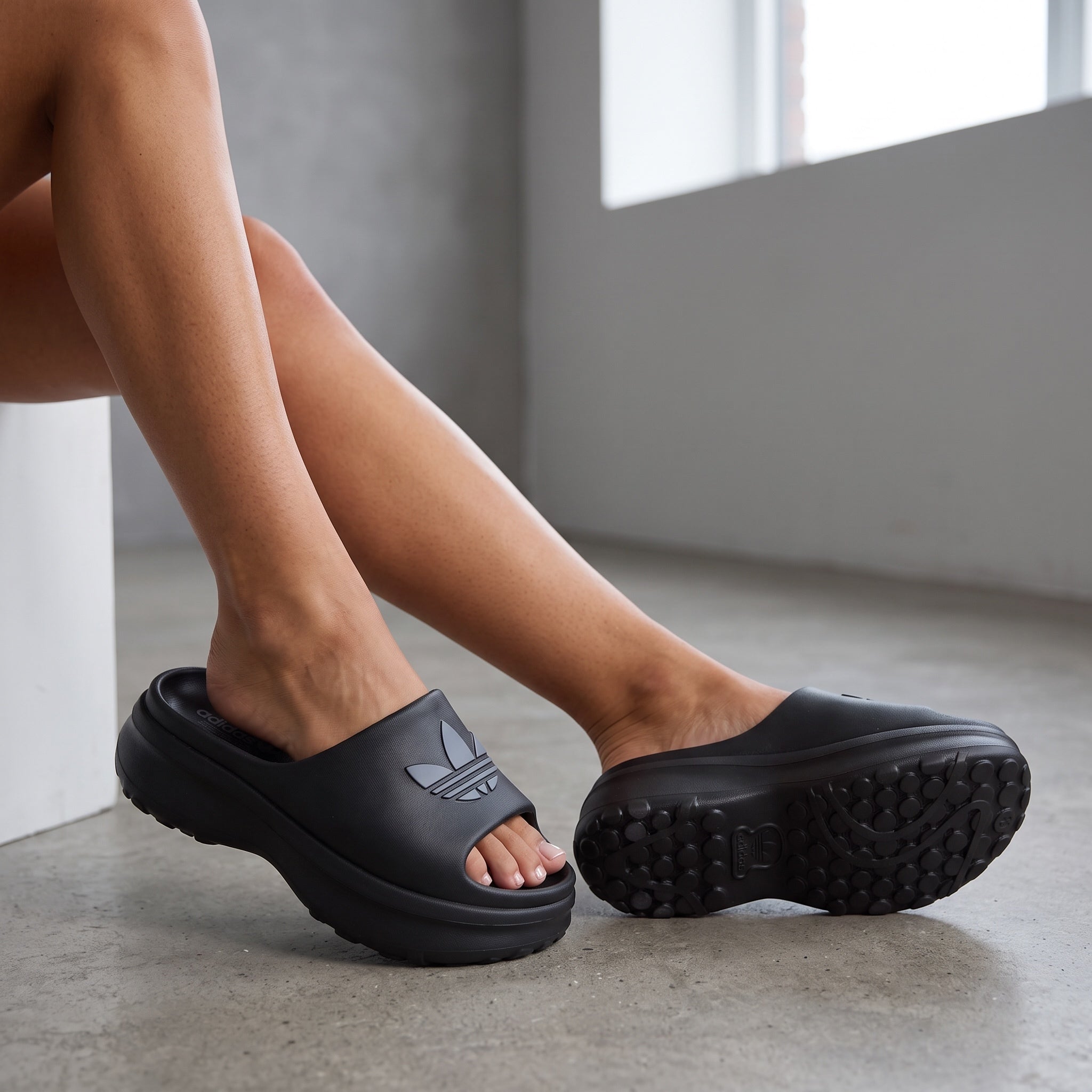 black adidas platform slide sandal with embossed trefoil