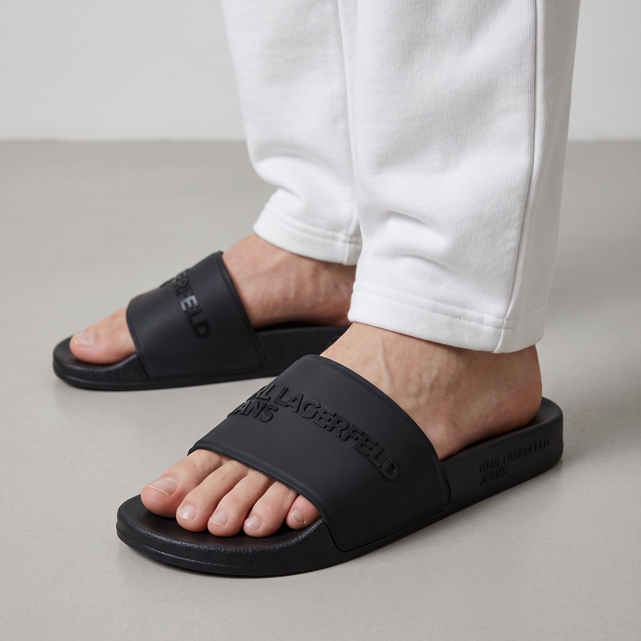 Karl Lagerfeld black single-strap pool slides with embossed logo