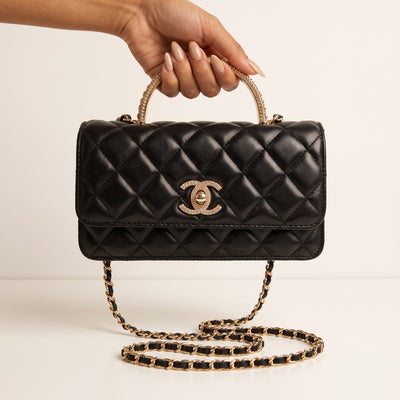 black quilted Chanel flap bag with gold chain strap and crystal top handle