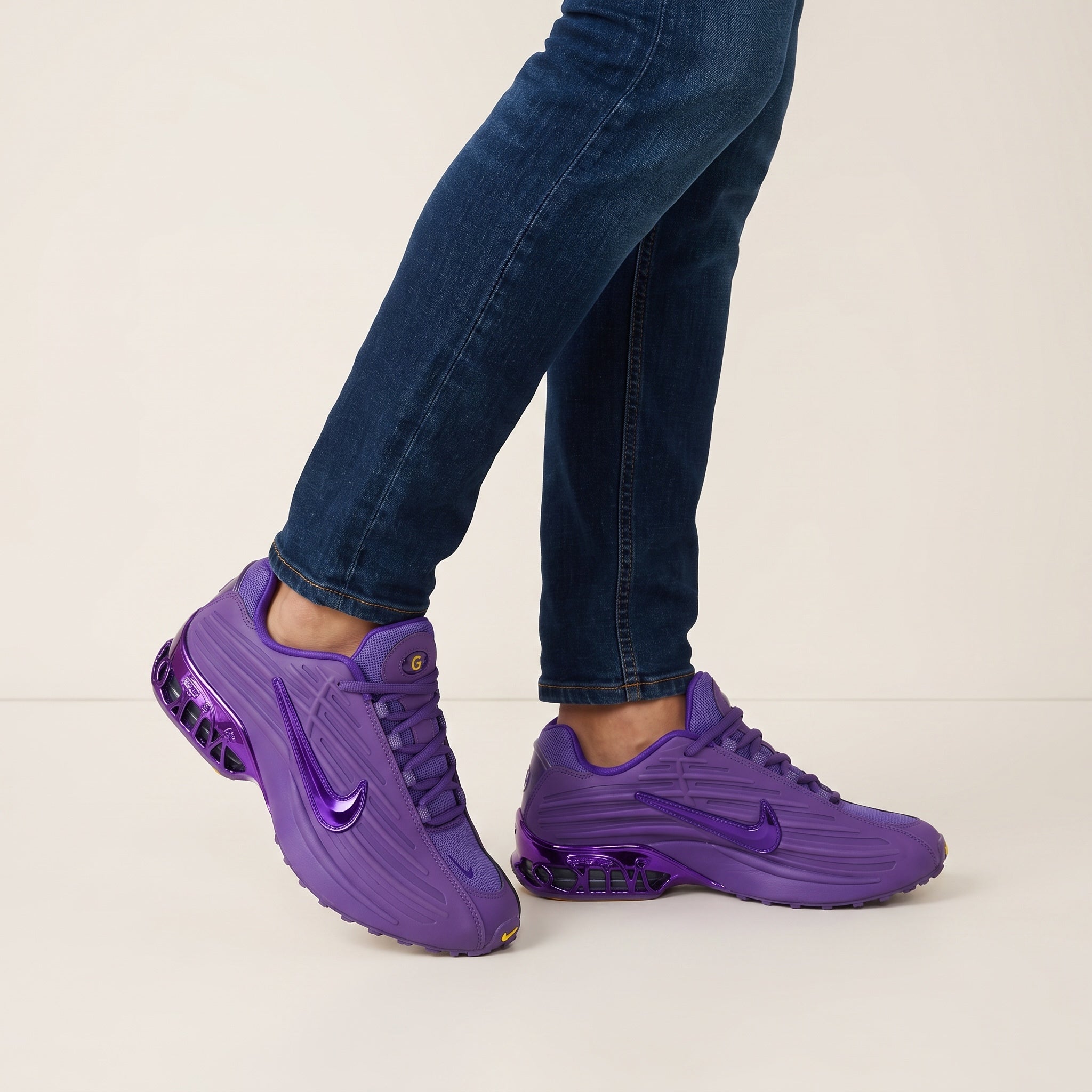 Pair of bright purple Nike sneakers with visible rear cushioning and glossy swoosh