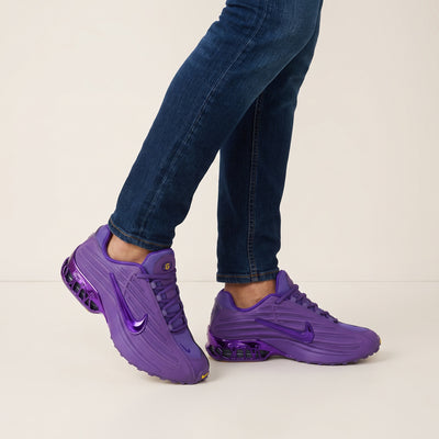 Pair of bright purple Nike sneakers with visible rear cushioning and glossy swoosh