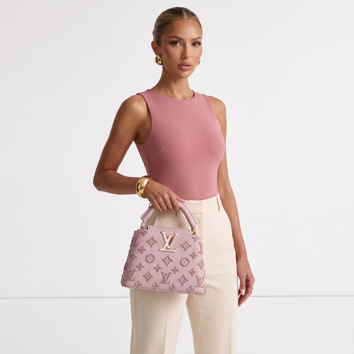 Pink Louis Vuitton Capucines top-handle bag with raised monogram and gold LV plaque