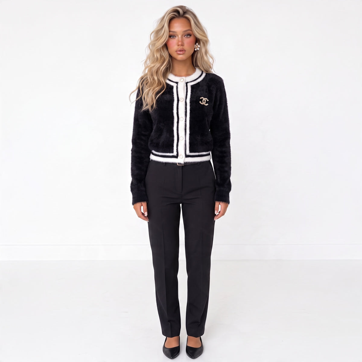 black cardigan with white trim, gold CC brooch and decorative buttons