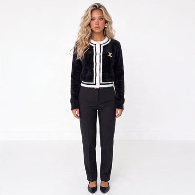 black cardigan with white trim, gold CC brooch and decorative buttons