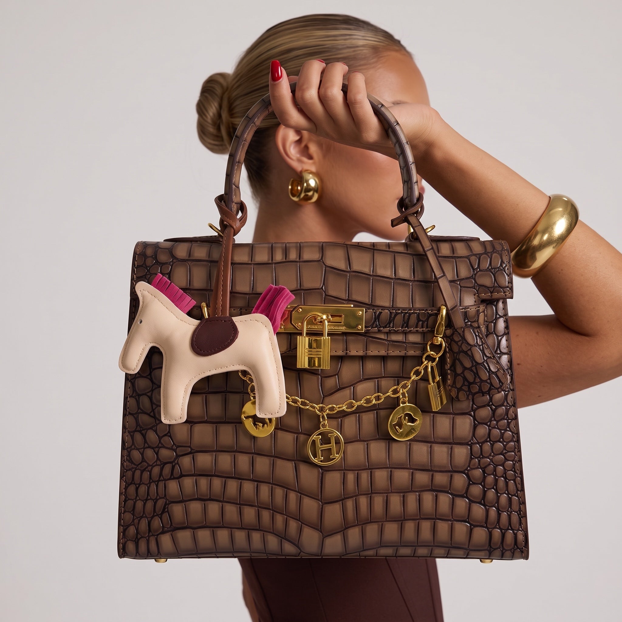 Brown croc-effect Hermès Kelly style top-handle bag with gold hardware and charm chain