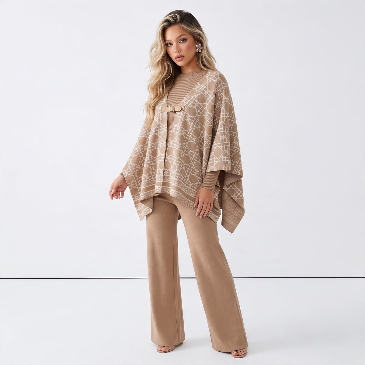 Beige geometric printed cape with front buckle worn over knit outfit