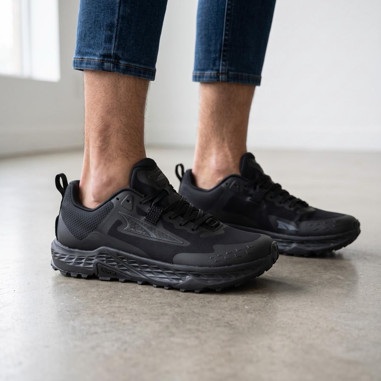 Altra black trail running shoes with Vibram outsole shown on feet