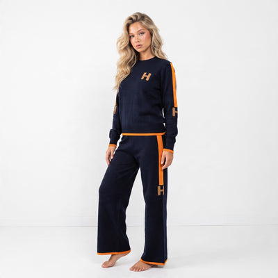 Navy knit crew top and matching wide-leg pants with orange side stripes and H logos