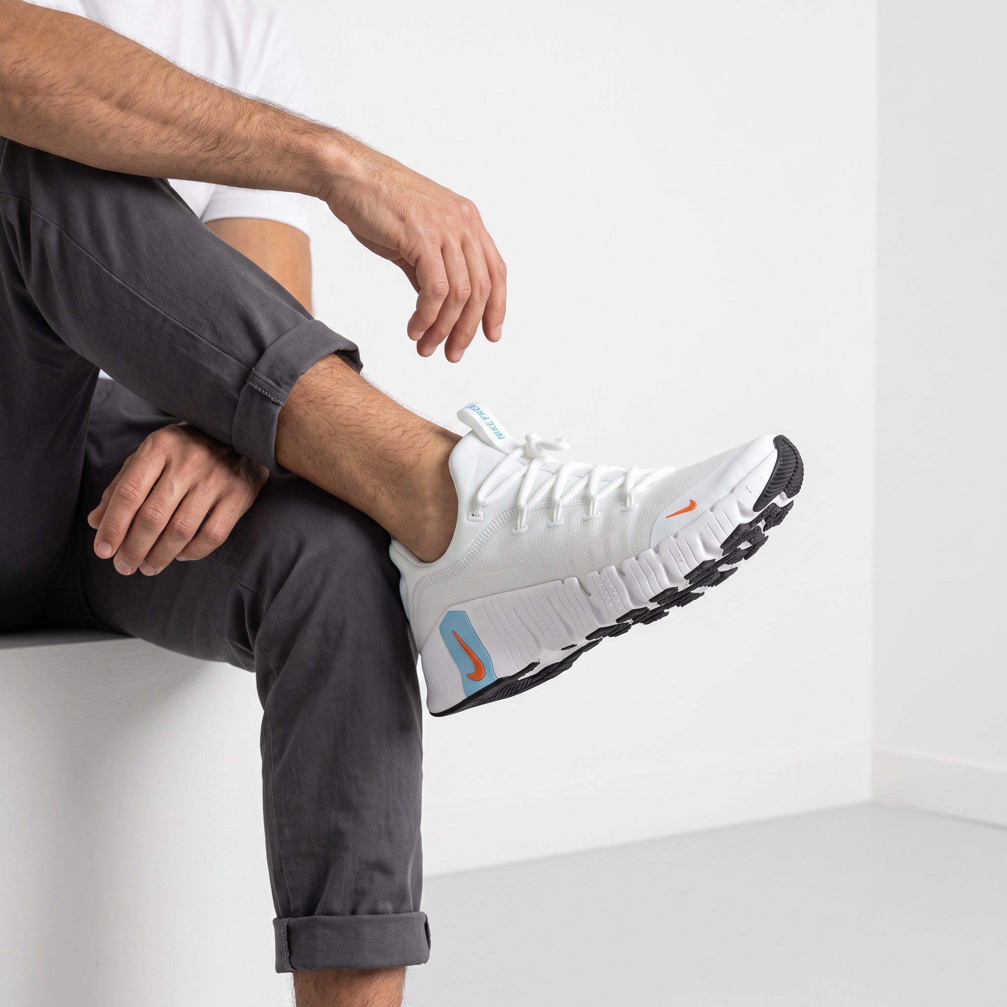 white Nike Free trainer with blue heel accent and orange swoosh