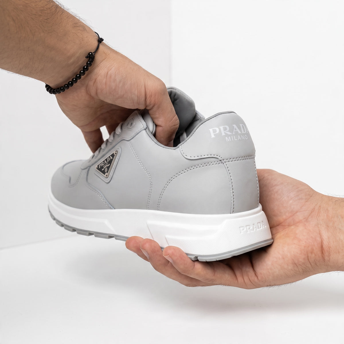 Prada grey low-top sneakers with triangular logo plaque and chunky white sole