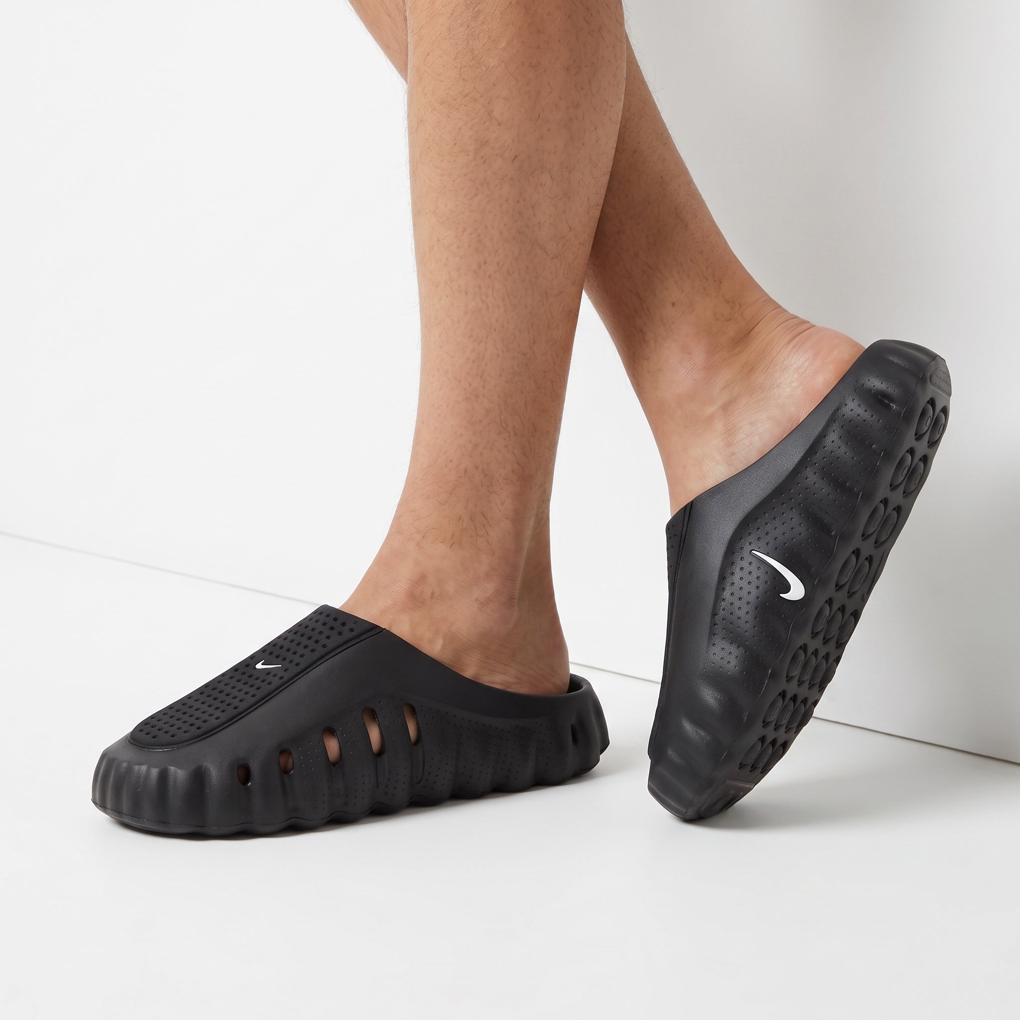 black Nike slip-on clog with perforated upper and white Swoosh