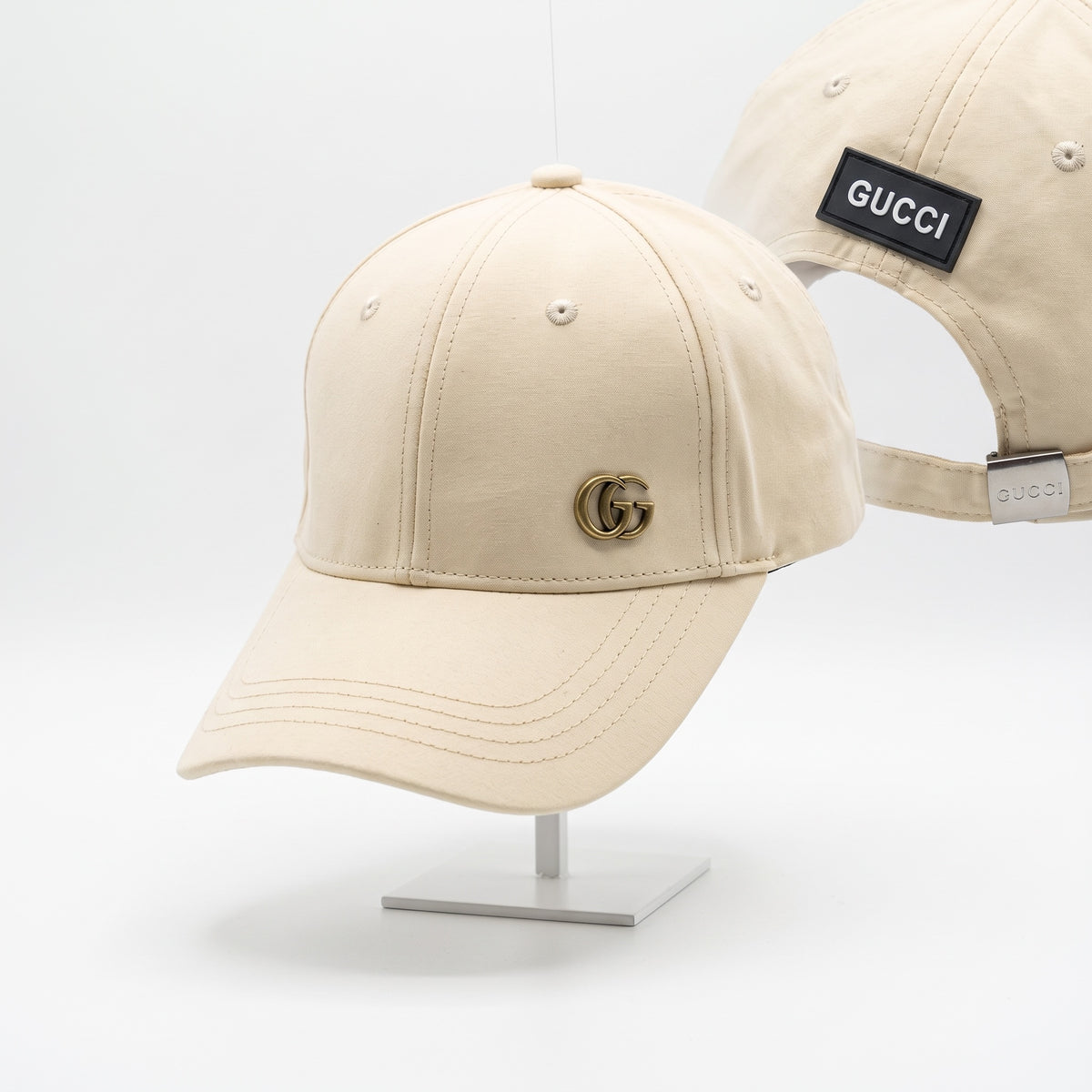 beige Gucci baseball cap with gold GG logo and adjustable strap