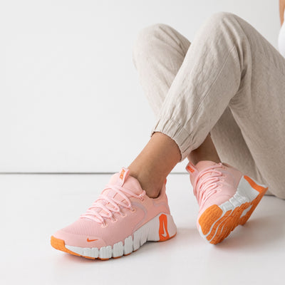 Pink Nike chunky sneakers with orange accents and white sole