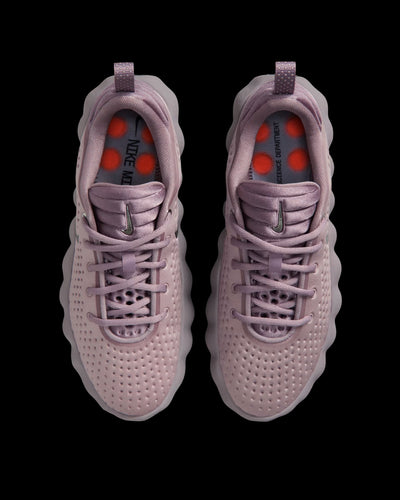 dusty pink nike sneaker with perforated upper and orange pod outsole
