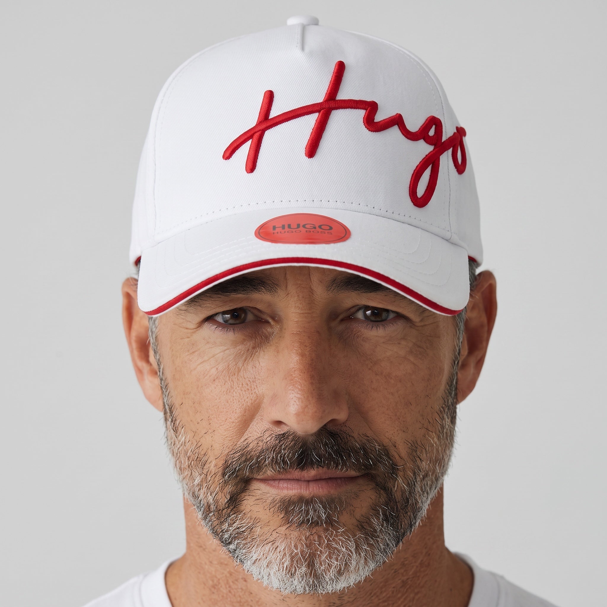 White Hugo Boss baseball cap with red embroidered script logo and red brim piping