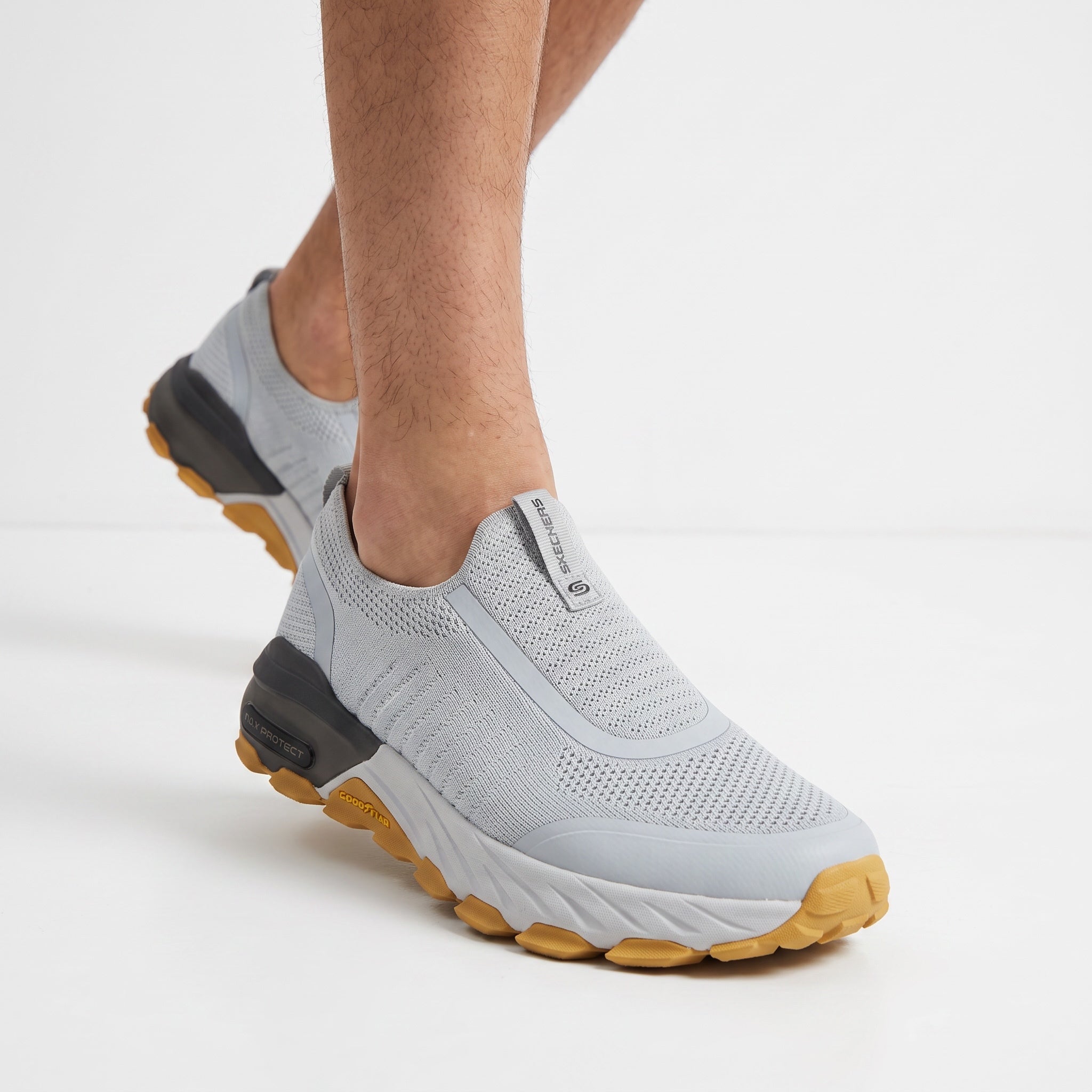 Light grey Skechers slip-on knit sneakers with yellow gum sole