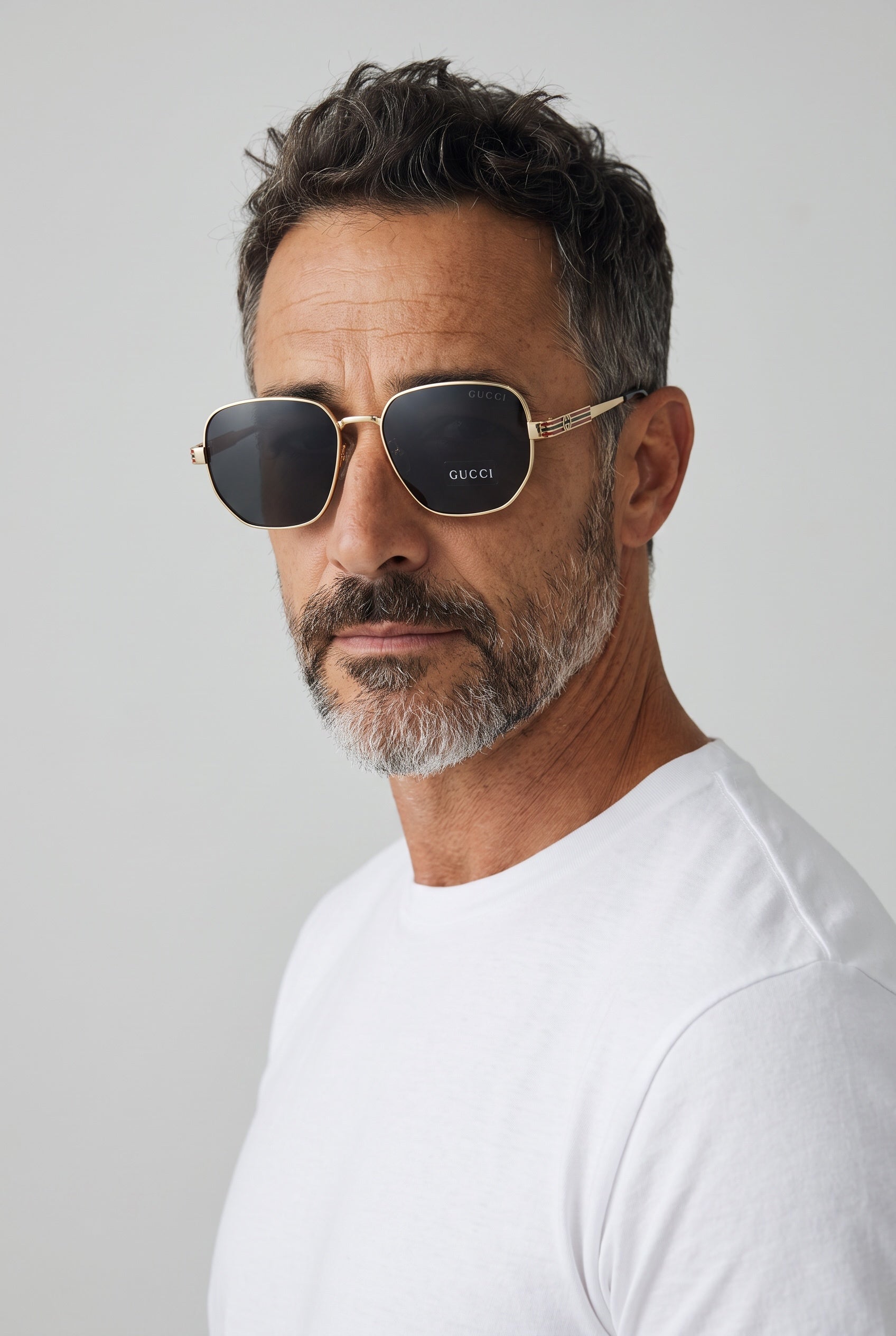 Gucci gold-tone sunglasses with dark polarized lenses and striped temples
