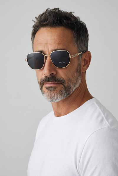 Gucci gold-tone sunglasses with dark polarized lenses and striped temples